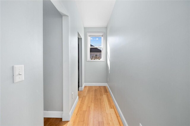 hallway featuring baseboards and light wood-type flooring