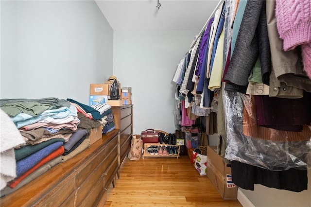 walk in closet with light hardwood / wood-style flooring