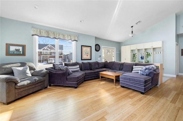 living room featuring high vaulted ceiling, plenty of natural light, and light hardwood / wood-style floors