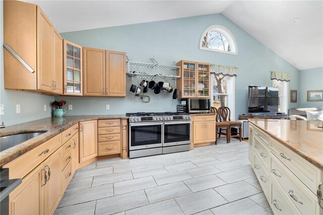 kitchen with range with two ovens, glass insert cabinets, light brown cabinetry, and a sink