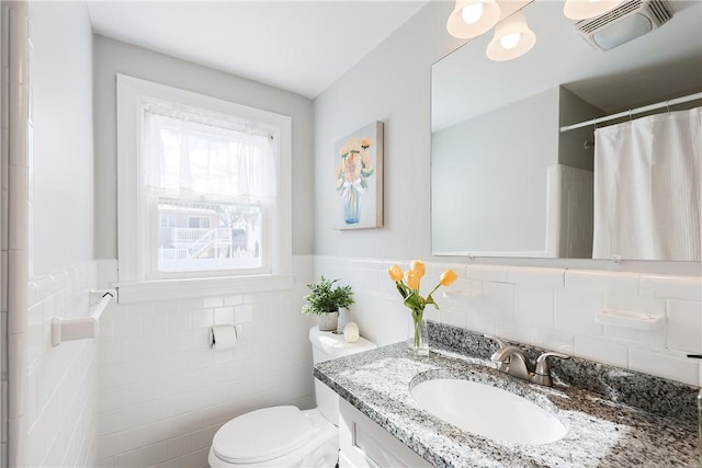 bathroom featuring vanity, a shower with shower curtain, tile walls, and toilet