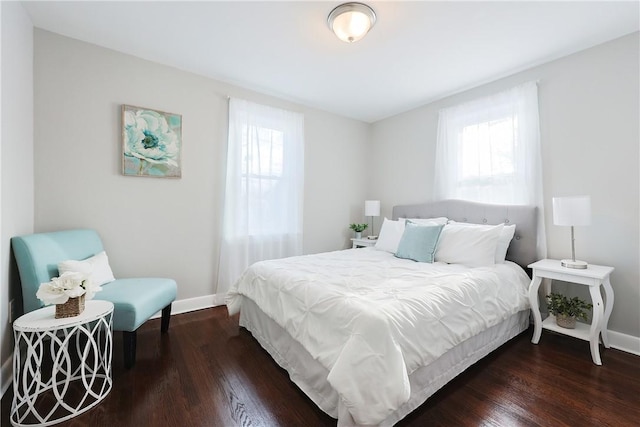 bedroom with multiple windows and dark wood-type flooring