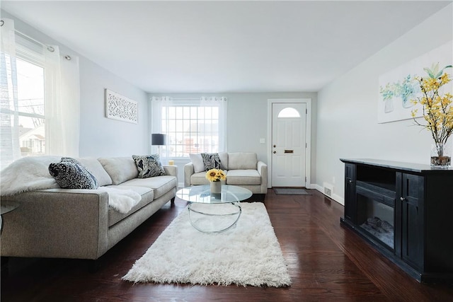 living room featuring plenty of natural light and dark hardwood / wood-style floors