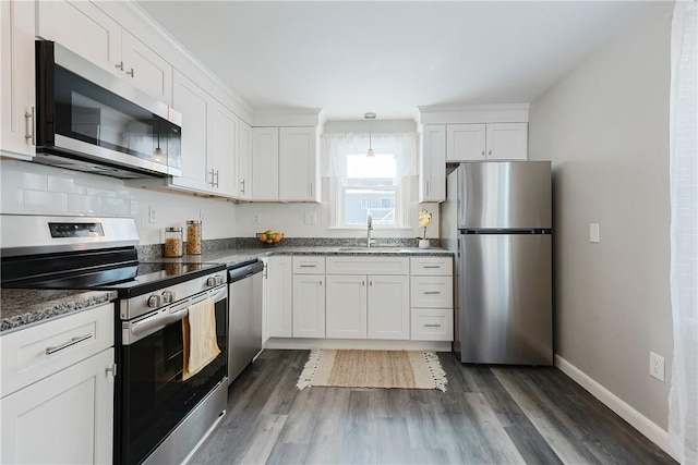 kitchen with white cabinetry, appliances with stainless steel finishes, sink, and dark hardwood / wood-style floors