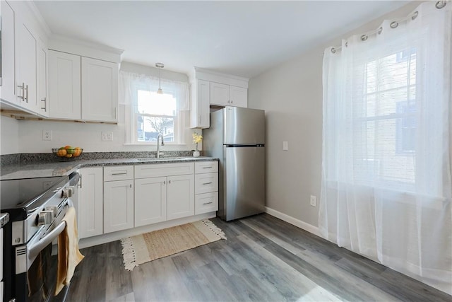 kitchen with hardwood / wood-style flooring, stainless steel appliances, sink, and white cabinets