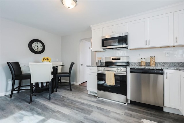 kitchen featuring stainless steel appliances, white cabinets, and light hardwood / wood-style flooring