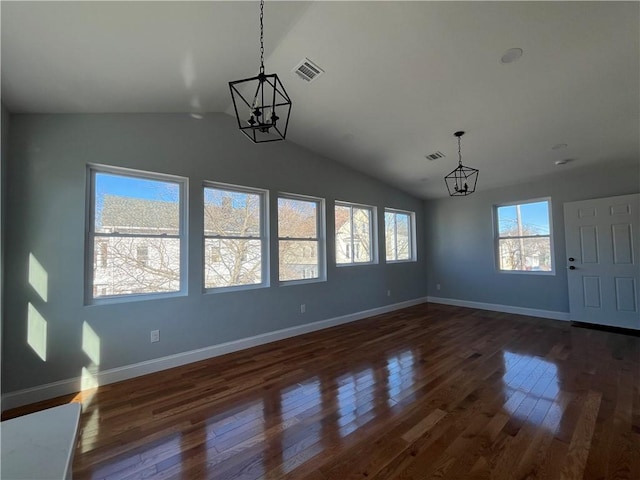 interior space featuring dark wood-type flooring, a chandelier, and vaulted ceiling