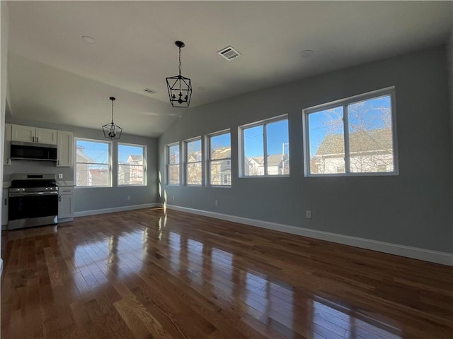 unfurnished living room with dark hardwood / wood-style flooring, lofted ceiling, and an inviting chandelier