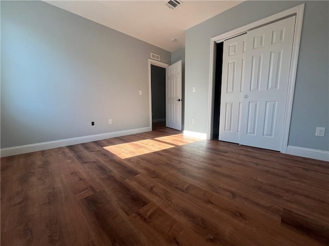 unfurnished bedroom featuring dark hardwood / wood-style floors and a closet