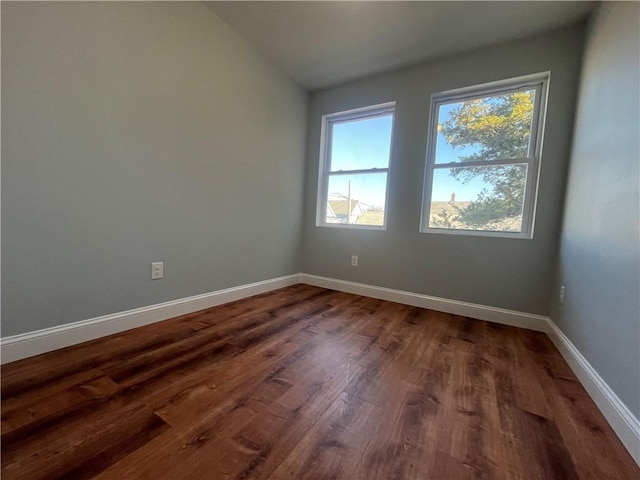 unfurnished room featuring dark hardwood / wood-style flooring and vaulted ceiling