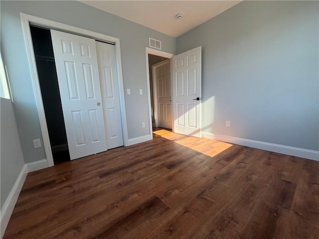 unfurnished bedroom featuring dark hardwood / wood-style floors and a closet