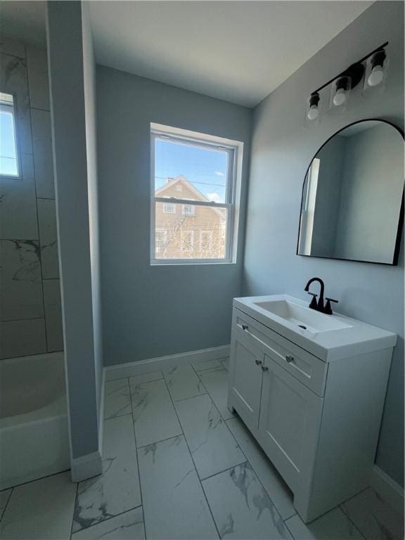 bathroom featuring tiled shower / bath, plenty of natural light, and vanity