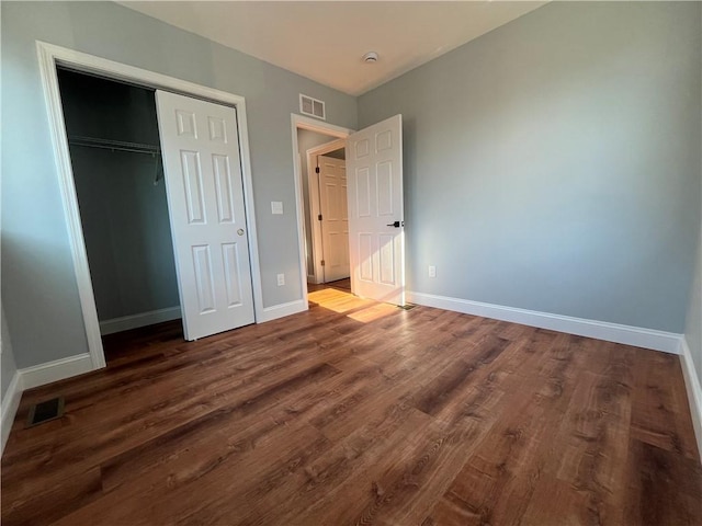 unfurnished bedroom with wood-type flooring and a closet