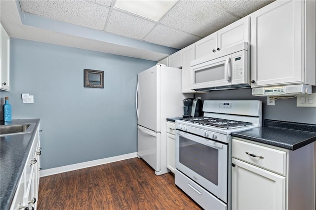 kitchen with white cabinetry, dark hardwood / wood-style flooring, a drop ceiling, and white appliances