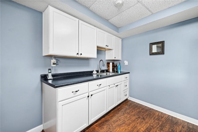 kitchen with dark hardwood / wood-style flooring, sink, and white cabinets