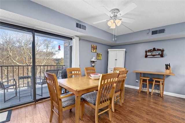 dining room with dark hardwood / wood-style floors, a textured ceiling, and ceiling fan