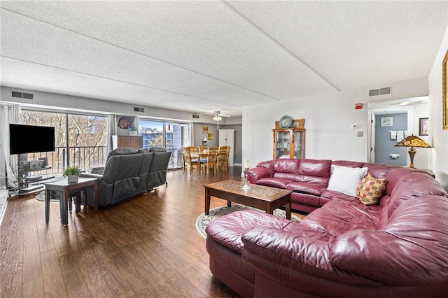 living room with dark wood-type flooring and a textured ceiling