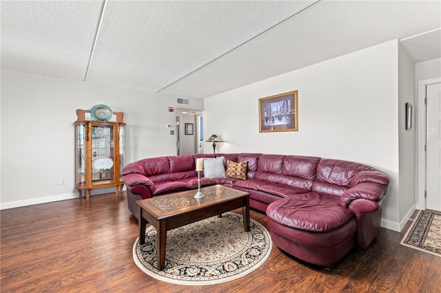 living room with a textured ceiling and dark hardwood / wood-style flooring