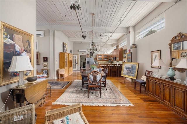 dining room featuring an AC wall unit, hardwood / wood-style floors, beam ceiling, wooden ceiling, and an inviting chandelier