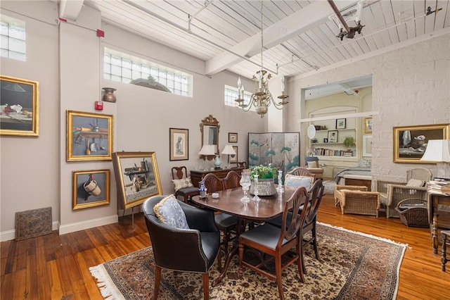 dining space featuring a notable chandelier, wood-type flooring, wooden ceiling, and beamed ceiling