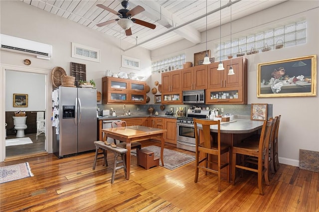 kitchen featuring stainless steel appliances, light hardwood / wood-style flooring, a wall mounted AC, and decorative backsplash