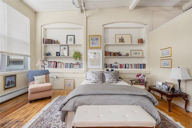 bedroom with hardwood / wood-style flooring, beam ceiling, and baseboard heating