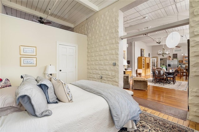 bedroom with wood ceiling, a chandelier, stainless steel fridge with ice dispenser, beam ceiling, and hardwood / wood-style floors