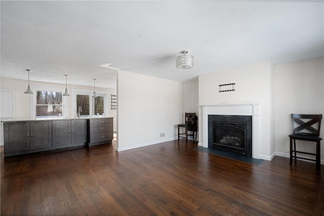 unfurnished living room featuring sink and dark hardwood / wood-style floors