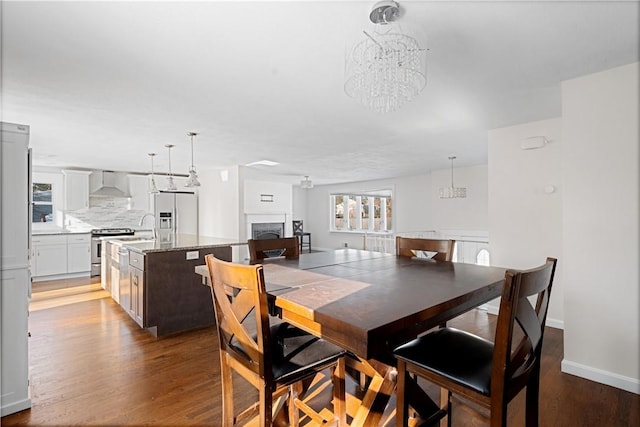 dining room featuring dark hardwood / wood-style floors, sink, and a notable chandelier