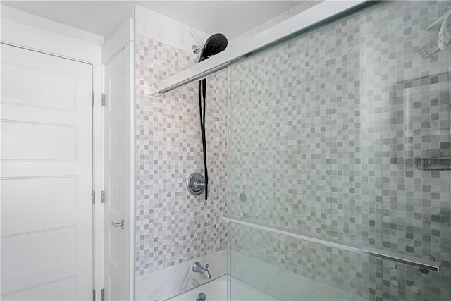 bathroom featuring combined bath / shower with glass door