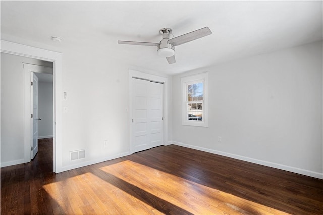 unfurnished bedroom with dark hardwood / wood-style floors, ceiling fan, and a closet