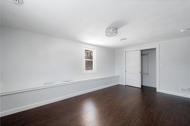 unfurnished room with dark hardwood / wood-style flooring