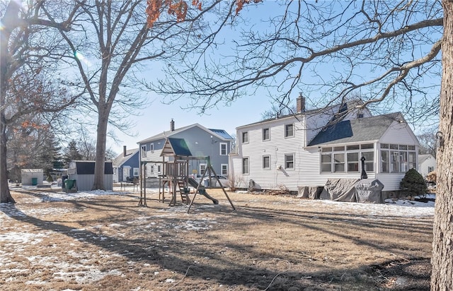 back of property featuring a sunroom and a playground