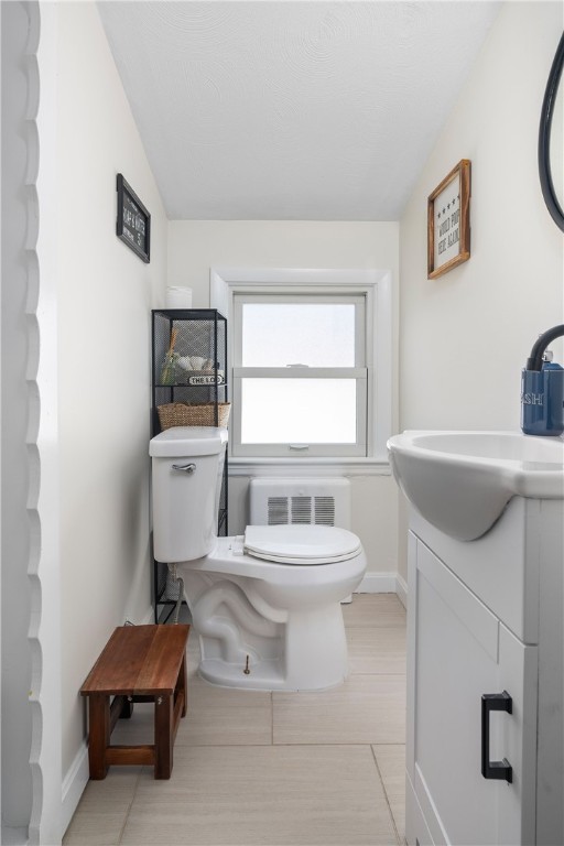 bathroom featuring vanity, vaulted ceiling, and toilet