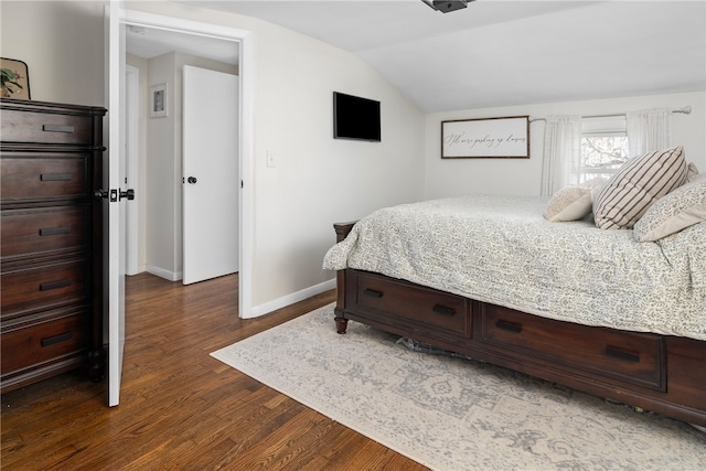 bedroom with dark wood-type flooring and vaulted ceiling