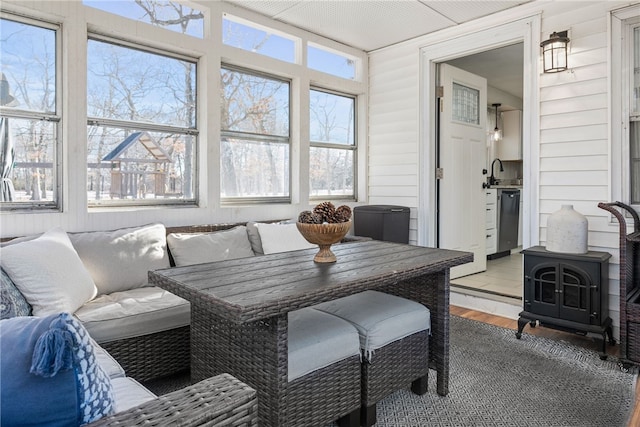 sunroom with sink and a wood stove