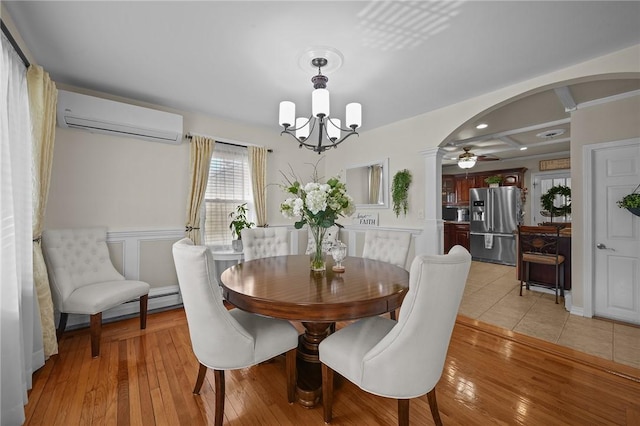 dining room featuring a wall mounted air conditioner, ceiling fan with notable chandelier, and light wood-type flooring