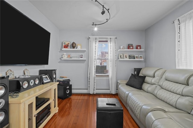 living room featuring rail lighting, hardwood / wood-style floors, and a baseboard heating unit