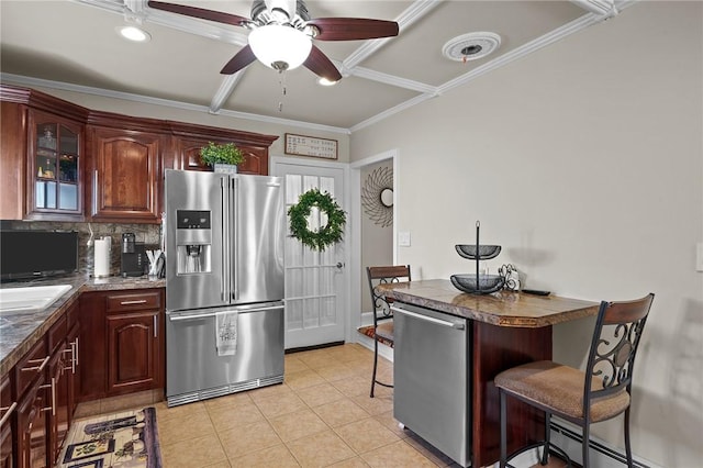 kitchen with a baseboard radiator, a breakfast bar area, light tile patterned floors, stainless steel appliances, and crown molding