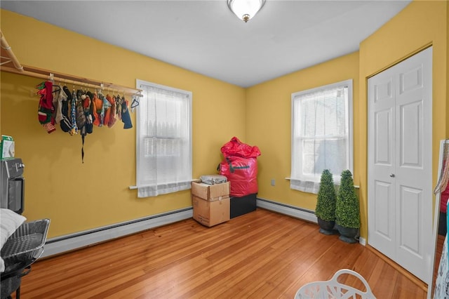 recreation room with baseboard heating and light wood-type flooring