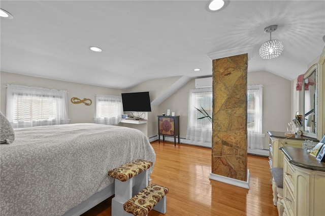 bedroom with lofted ceiling, a wall mounted air conditioner, a baseboard radiator, and light hardwood / wood-style floors