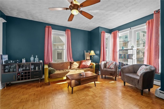 living area with parquet floors, a baseboard radiator, and a textured ceiling