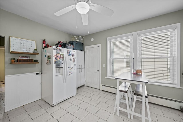 kitchen featuring ceiling fan, a baseboard heating unit, light tile patterned floors, and white fridge with ice dispenser