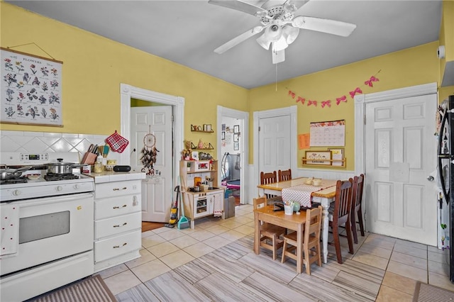 kitchen with light tile patterned flooring, ceiling fan, white gas range, and tasteful backsplash