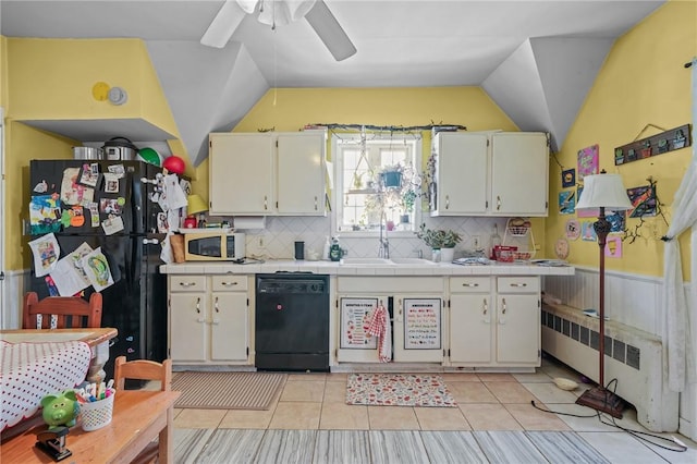 kitchen featuring lofted ceiling, sink, radiator heating unit, and black appliances