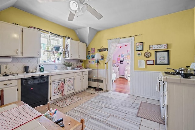 kitchen with sink, white cabinetry, tile countertops, radiator, and dishwasher