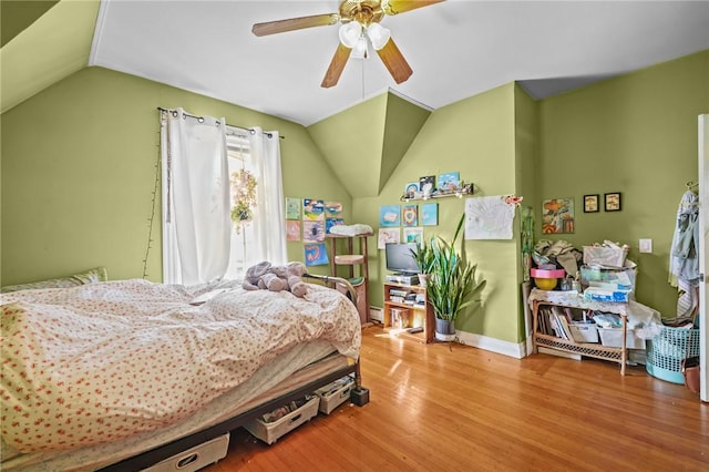 bedroom with lofted ceiling, a baseboard heating unit, hardwood / wood-style floors, and ceiling fan