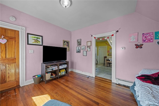 living room with lofted ceiling, a baseboard radiator, and wood-type flooring