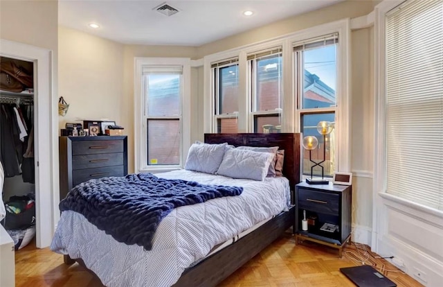 bedroom featuring light parquet floors and a closet