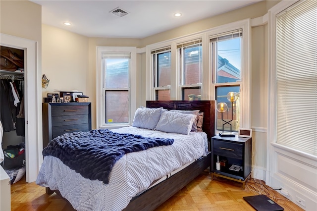 bedroom with light parquet floors and a closet